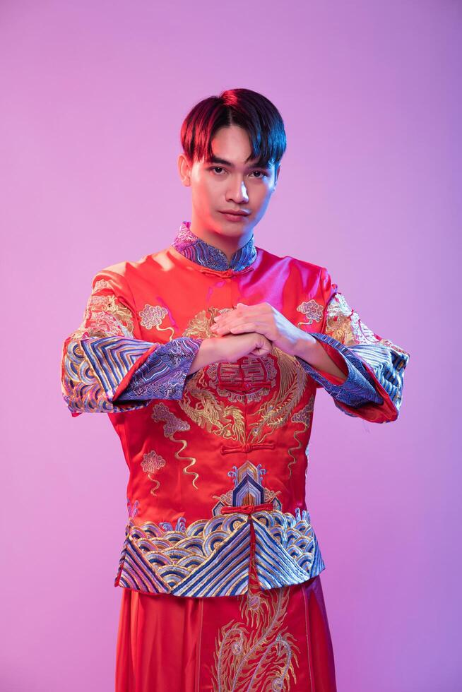 A man wear cheongsam is standing and respect customer who come to shop in chinese new year photo