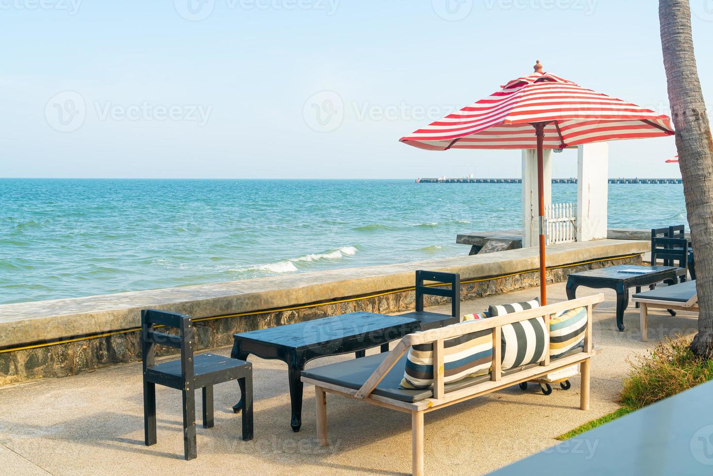 empty bench sofa with umbrella and ocean sea background photo