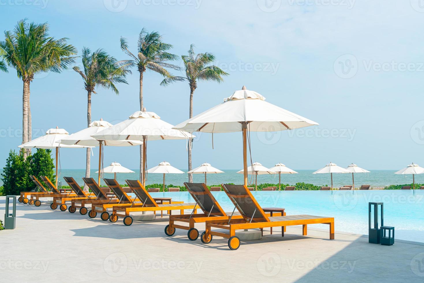 umbrella with bed pool around swimming pool with ocean sea background