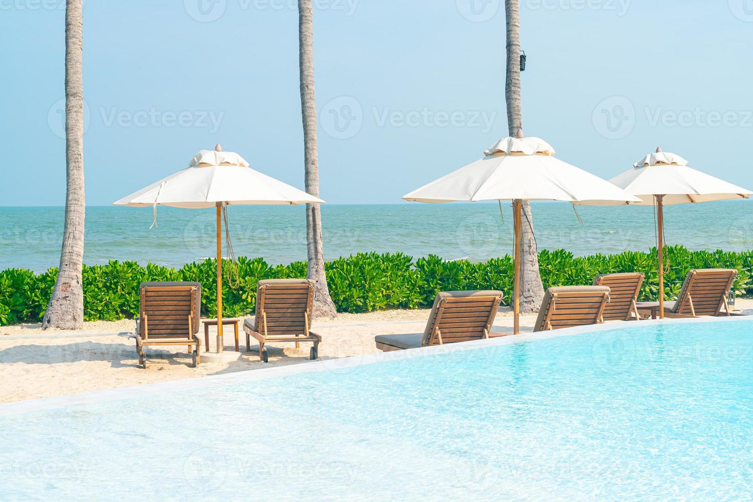 umbrella with bed pool around swimming pool with ocean sea background photo