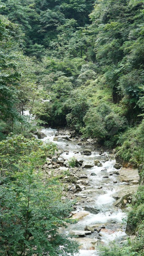 la hermosa vista al campo con la cascada que fluye en las montañas después del día lluvioso foto