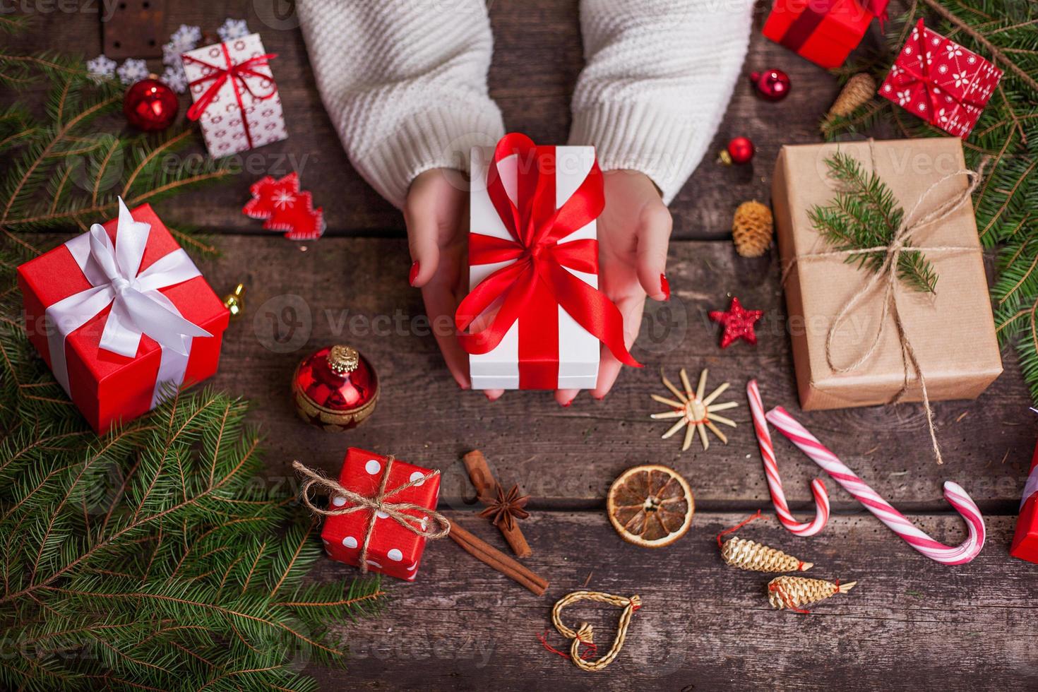 Mujer sosteniendo una caja de regalo en un gesto de dar. foto