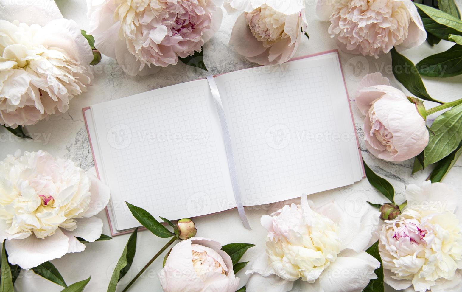 flores de peonía y cuaderno vacío foto