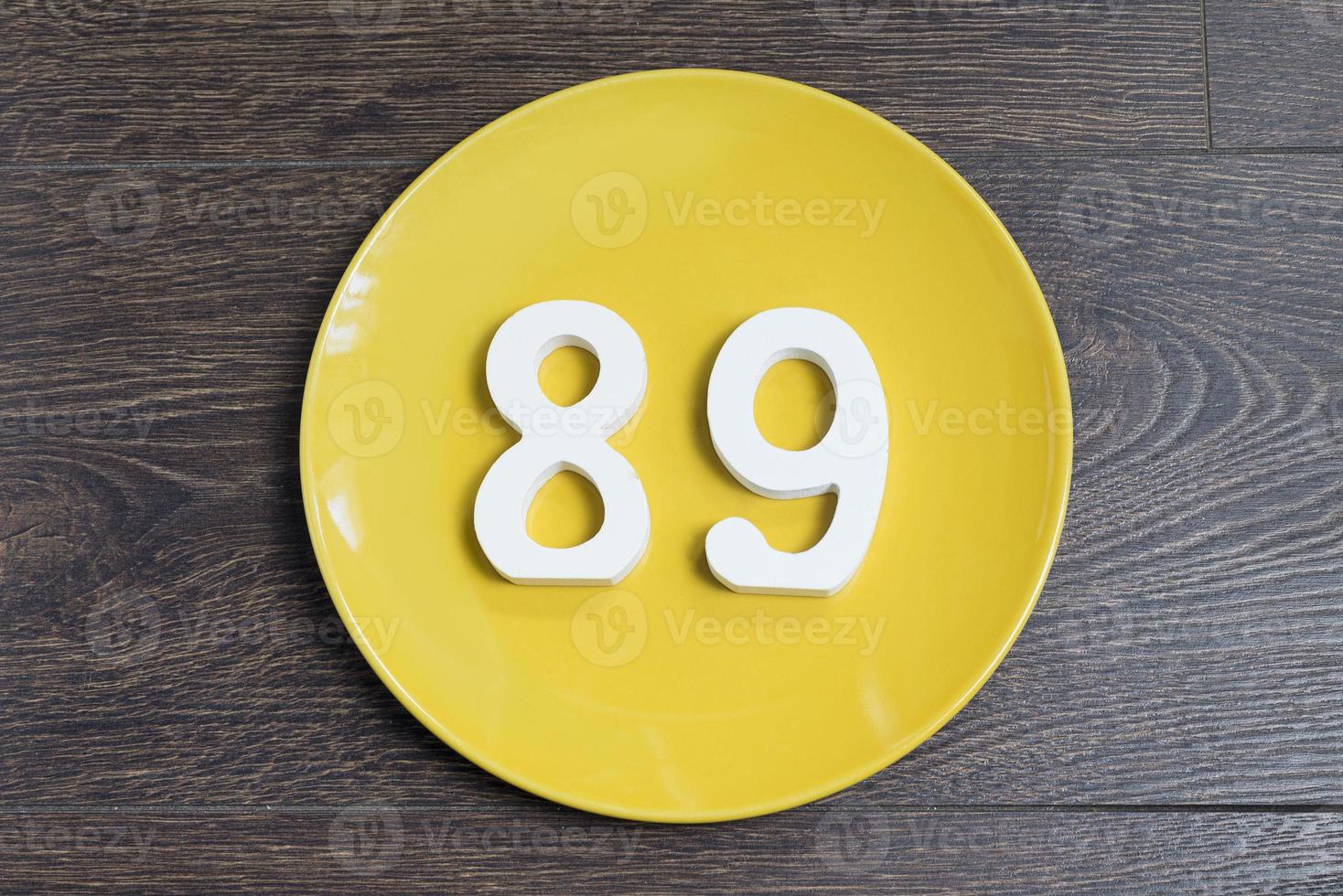 The number eighty-nine on a yellow plate. photo