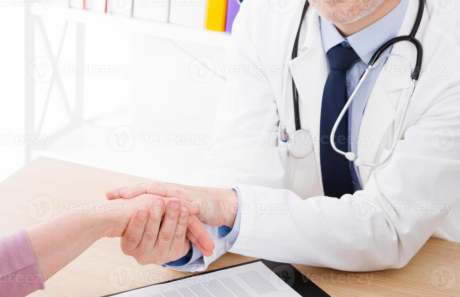 Friendly doctor hold patient hand in office. Examination result, positive test, calm down, promise and cheer up.Grief and suffer, treatment, condolence, ethics concept. photo