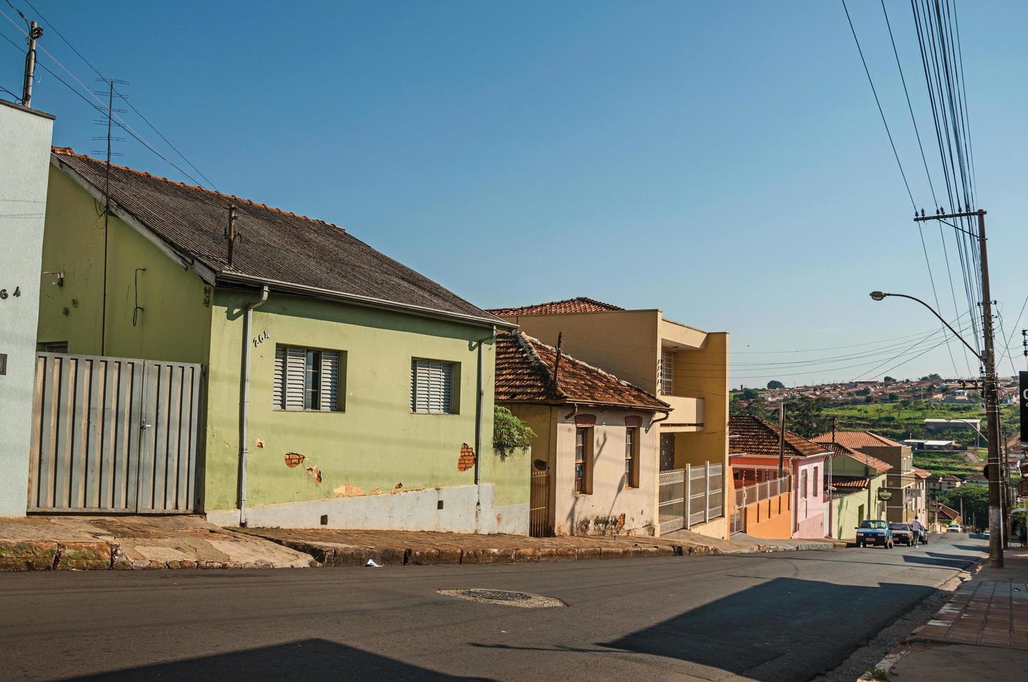 Sao Manuel, Brazil, October 14, 2017. Downhill street view with sidewalk walls and colorful houses on a sunny day at Sao Manuel. A cute little town in the countryside of Sao Paulo State. photo