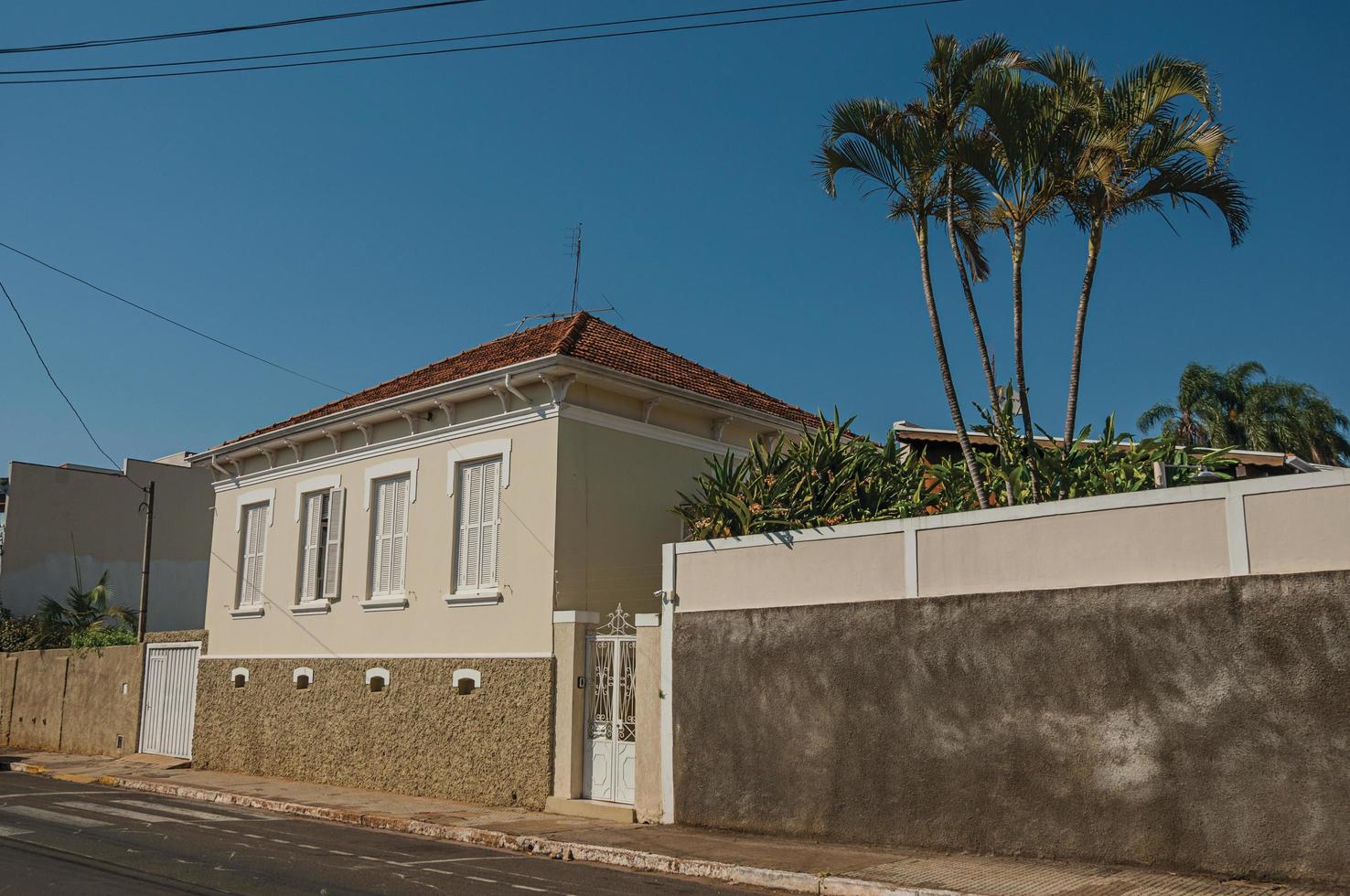Sao Manuel, Brazil, October 14, 2017. Working-class old house with wall in an empty street on a sunny day at Sao Manuel. A cute little town in the countryside of Sao Paulo State. photo