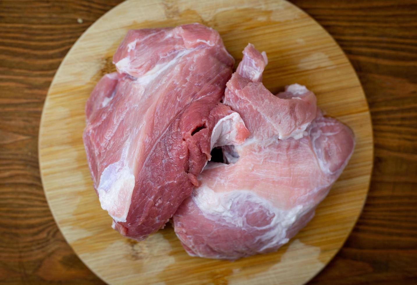 Raw pork meat on a cutting board. Top view. photo
