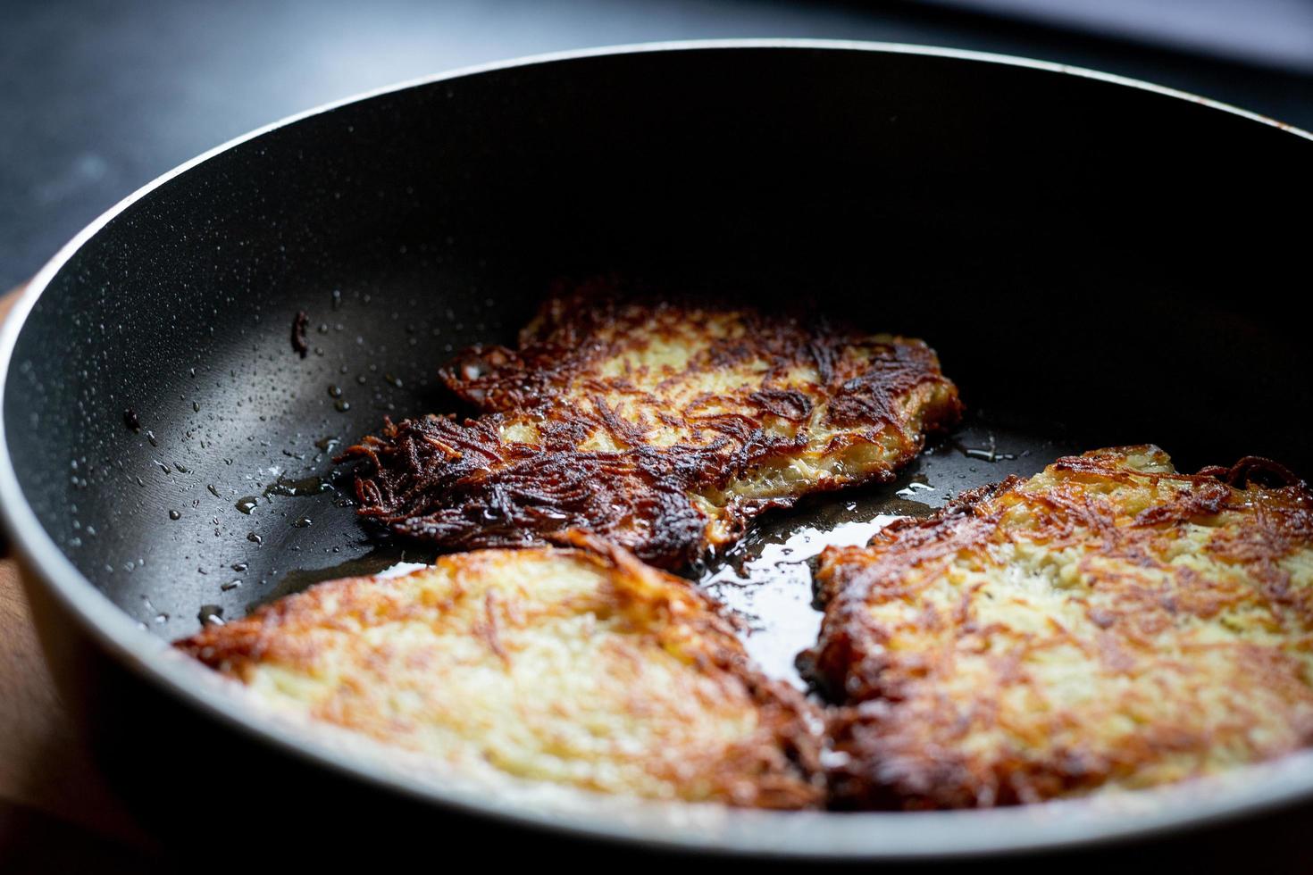 tortitas de patata fritas en una sartén. preparando la cena. foto