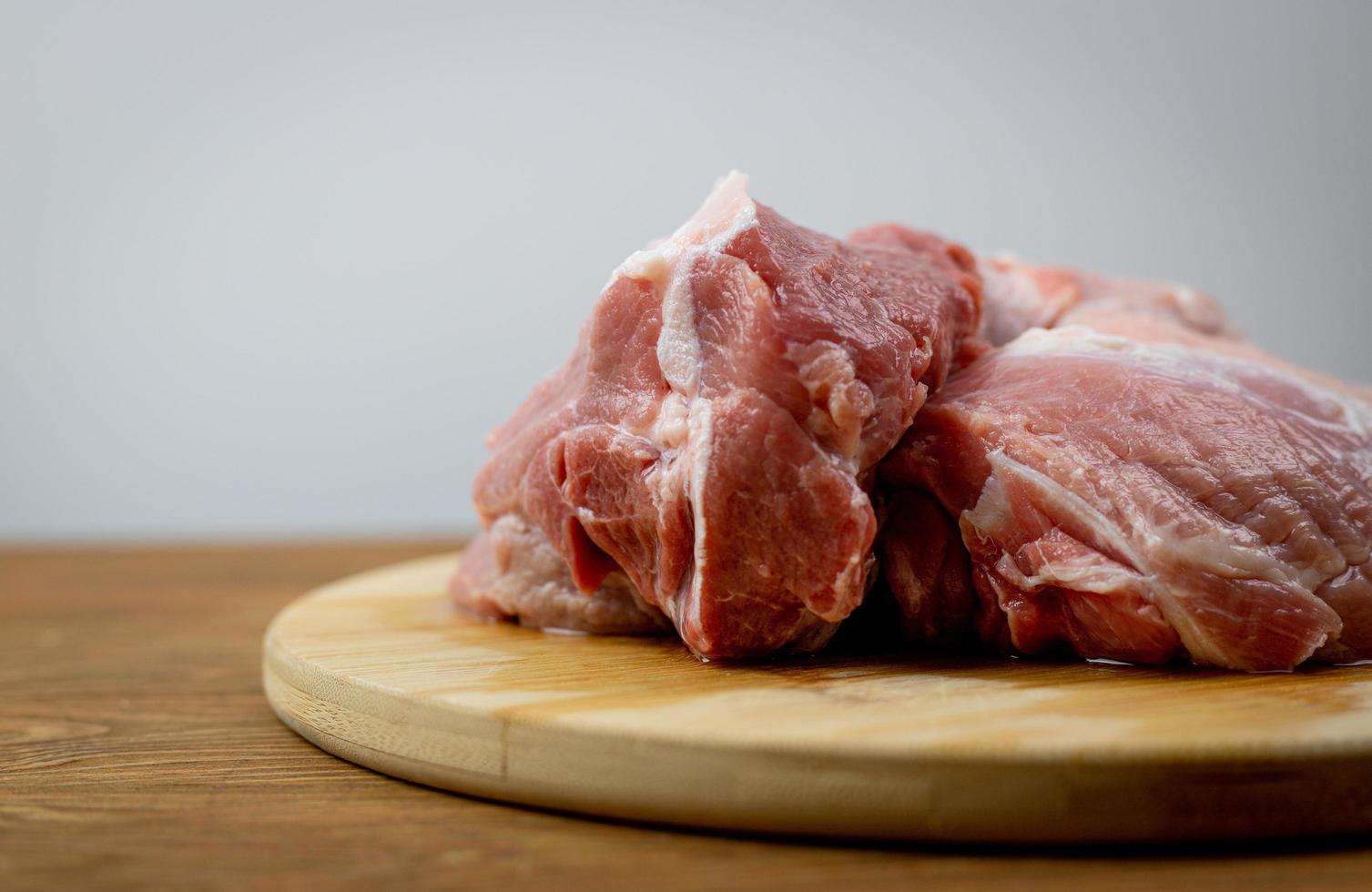 carne de cerdo cruda sobre una tabla para cortar. foto