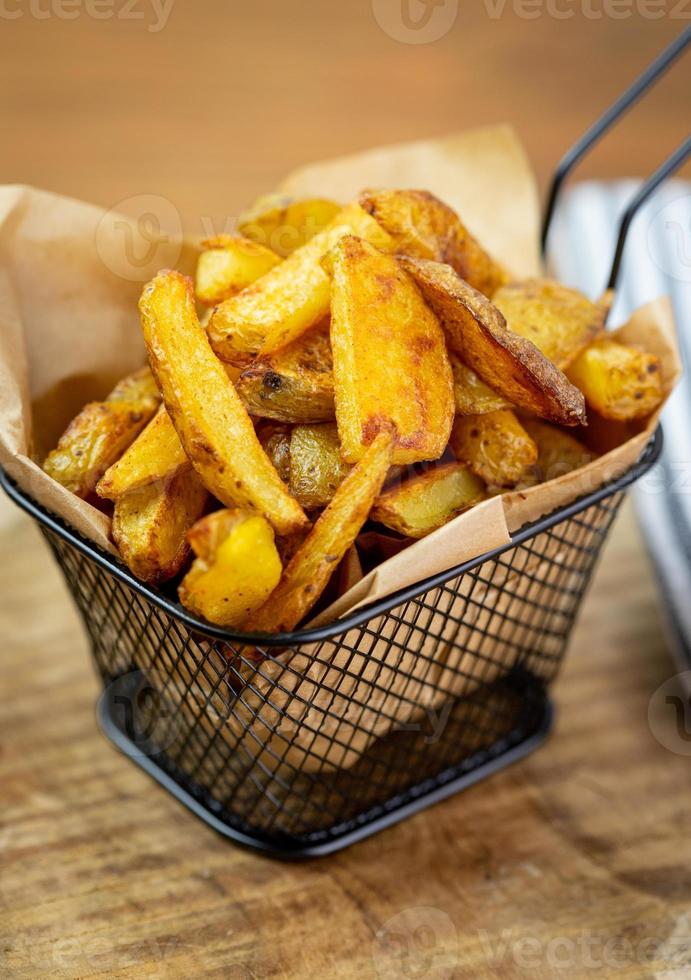 papas fritas caseras en una canasta de metal. foto