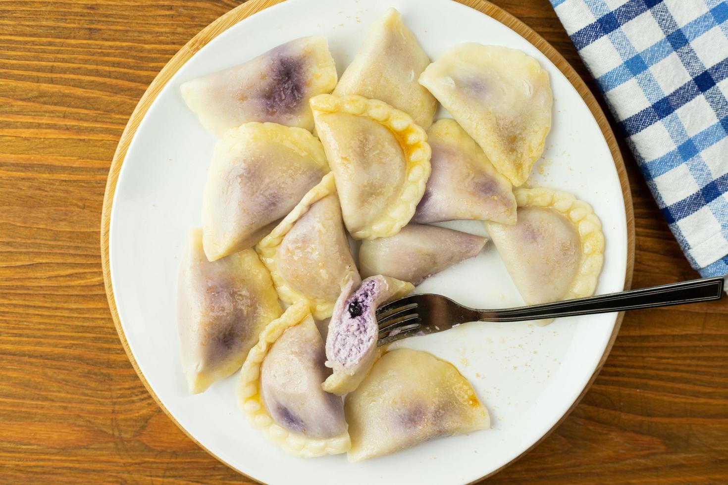 Dumplings stuffed with blueberries. Boiled in water, sprinkled with sugar and butter. photo