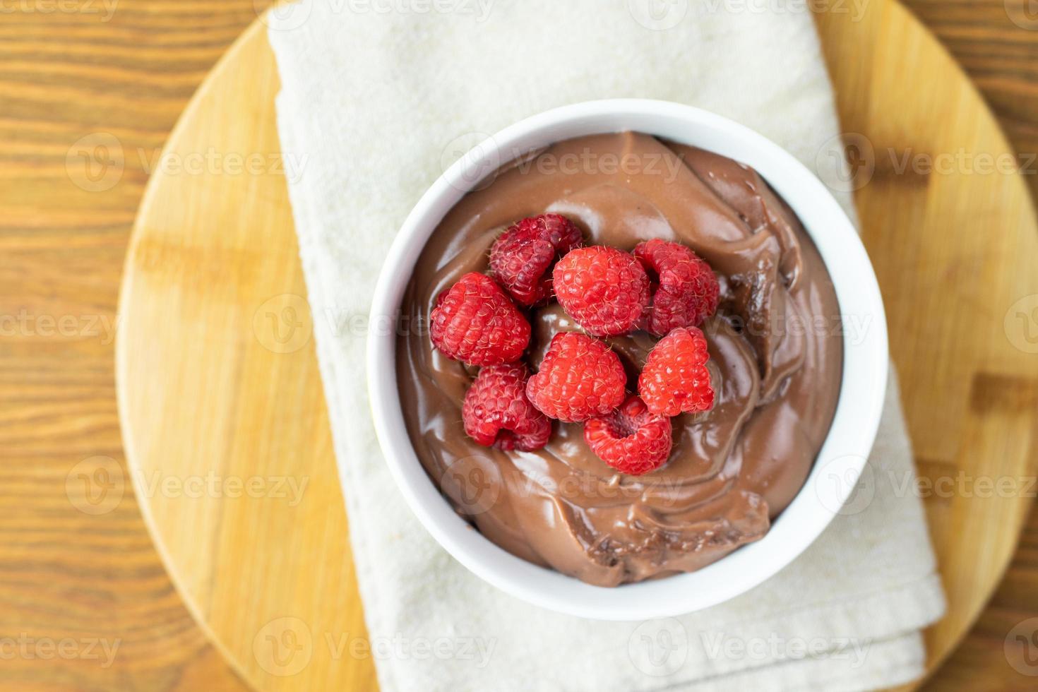 Chocolate pudding with raspberries on a wooden table. photo