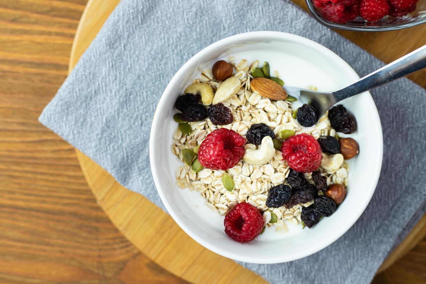 Oatmeal with raspberries, nuts and natural yoghurt. Healthy breakfast. photo