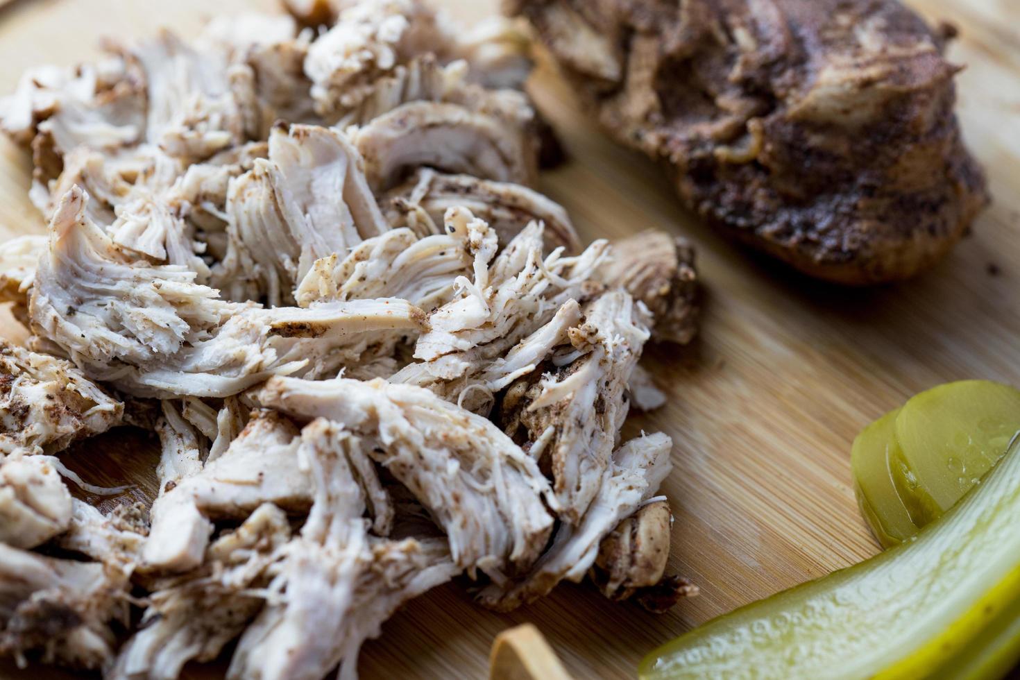 Pulled chicken with bread and pickled cucumber. photo