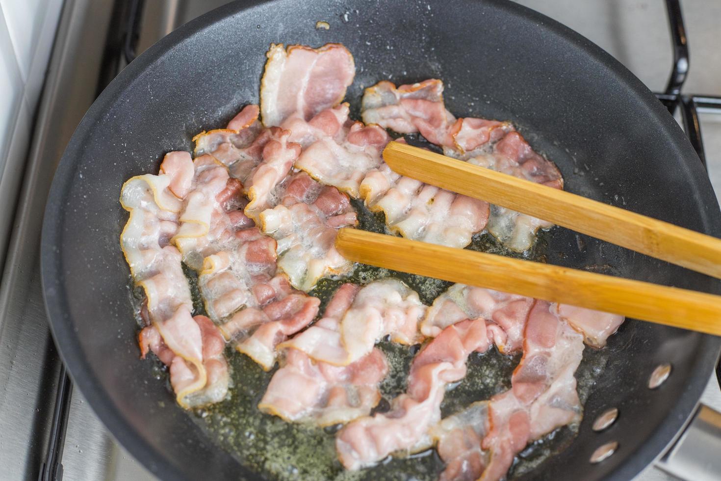 Bacon slices fried in a pan. View from above. photo