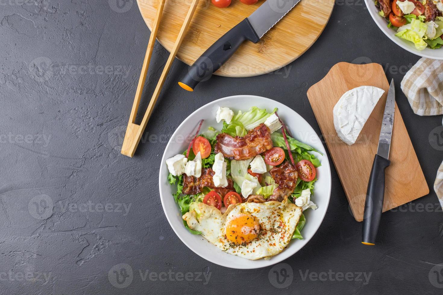 ensalada cetogénica. huevo frito con tocino, tomates, queso azul y lechuga. receta para la ensalada cetogénica perfecta. vista desde arriba. foto