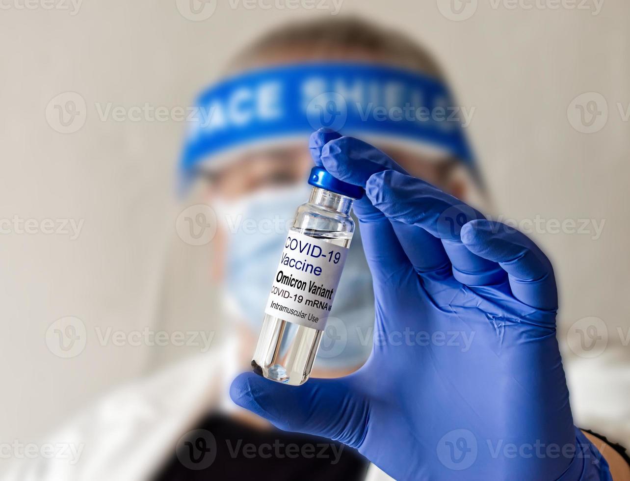 Selective focus Doctor hand holding vaccine dose for Covid-19 Omicron Variant. Blurred background. Omicron variant concept photo