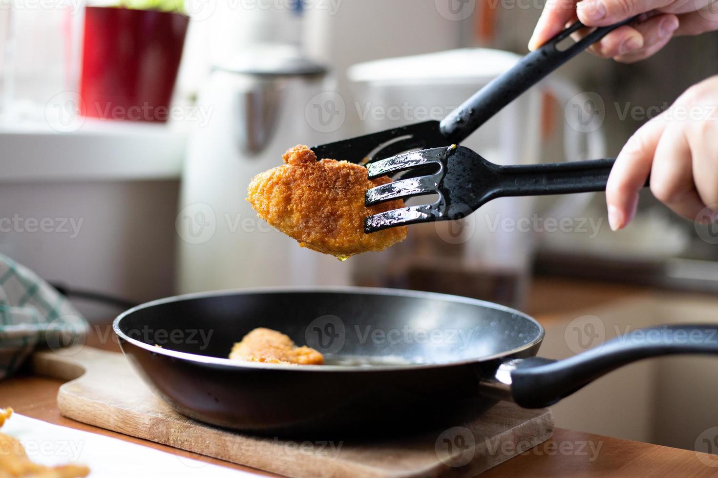 Fried pieces of breaded chicken. Preparation of a traditional dinner. photo