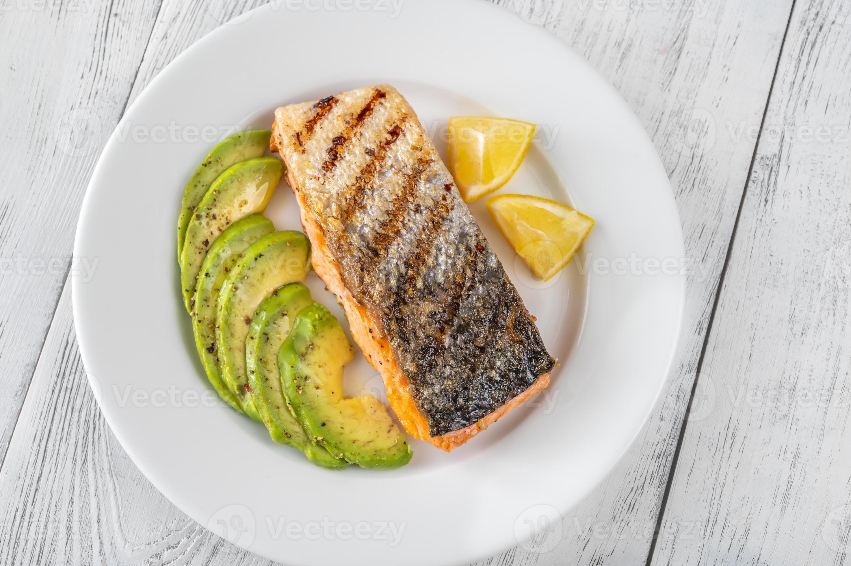 salmón frito con rodajas de aguacate 4961955 Foto de stock en Vecteezy