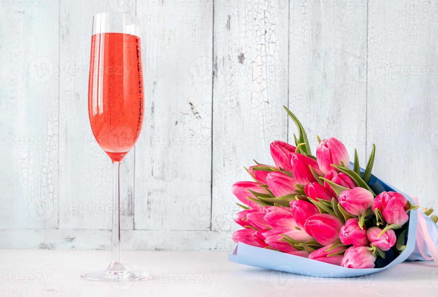 Bouquet of tulips with glass of champagne photo