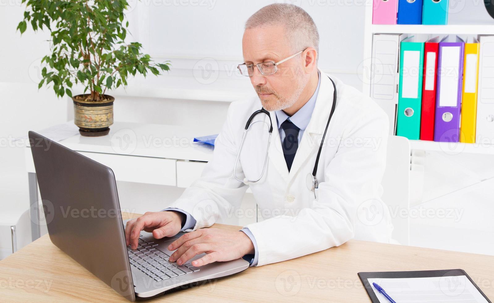 doctor in the medical office works at the computer photo