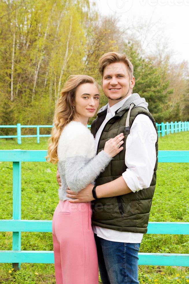 Cheerful couple embracing and posing on the green grass a sunny day photo