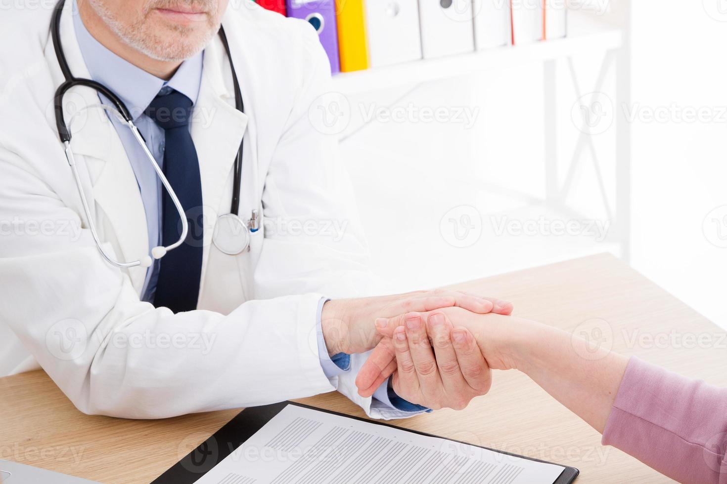 doctor hold patient hand in office. Examination result, positive test, calm down, promise and cheer up. Medical insurance. Grief and suffer, treatment, condolence, ethics concept. photo