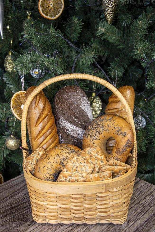 Bread in a basket. Bakery products stand in a wicker basket near the Christmas tree. photo
