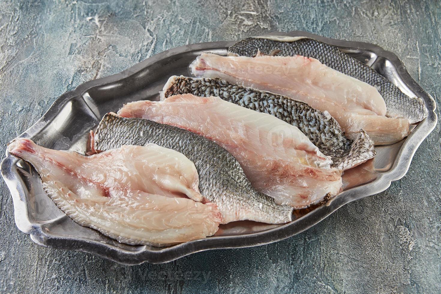 Fresh bass fish, ready to cook on tray photo