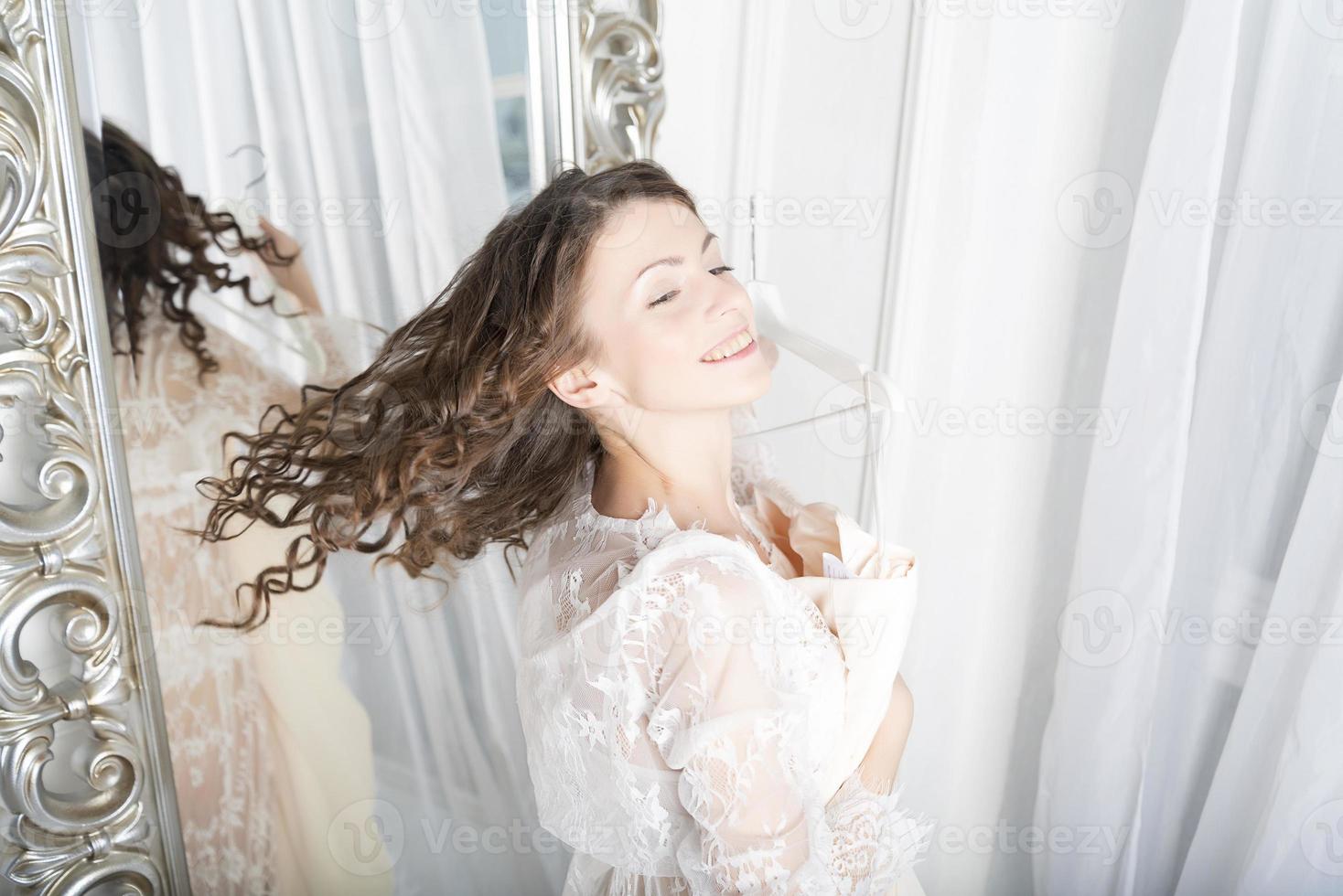 Girl in a white dress at the mirror. photo