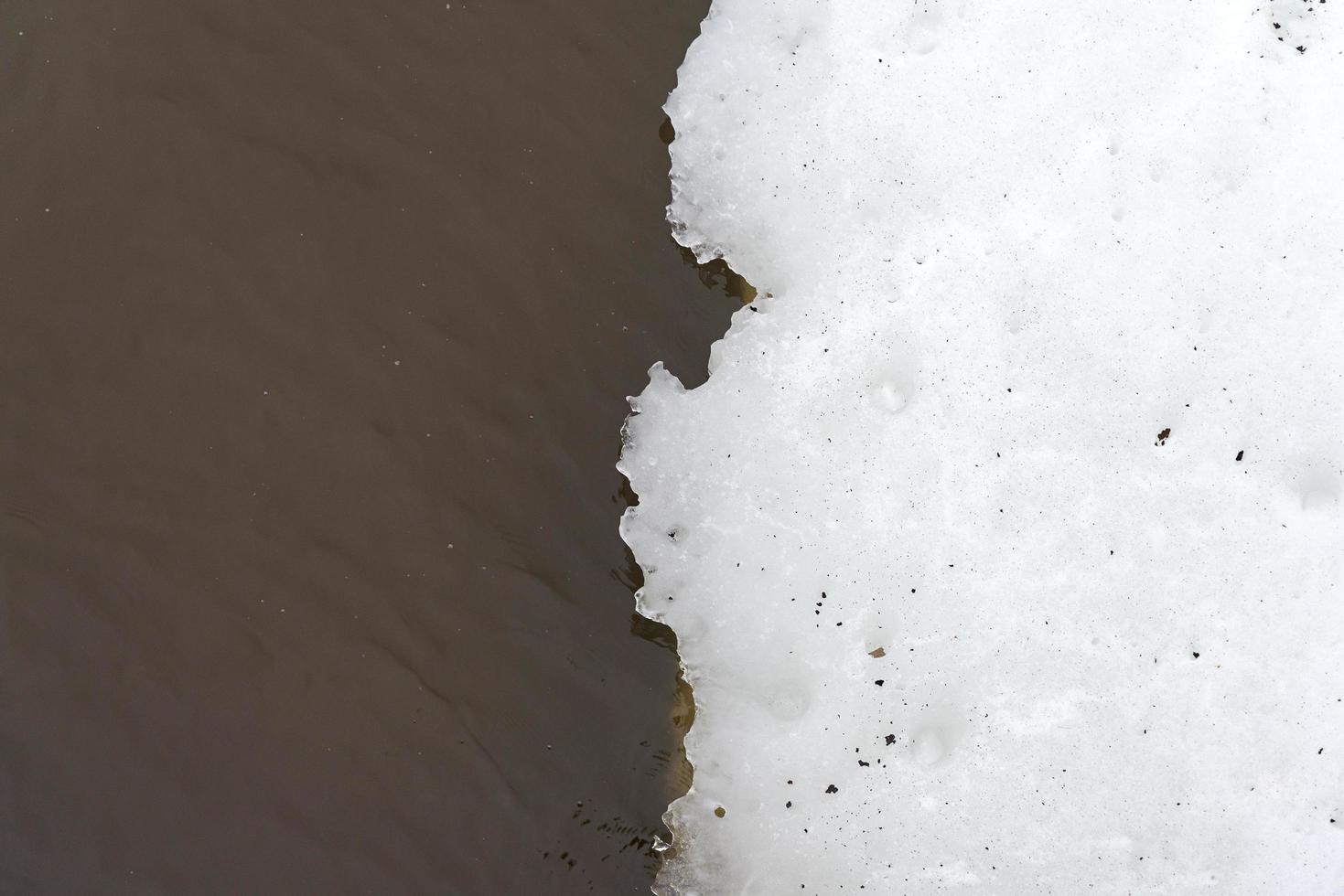 agua marrón y nieve blanca. foto