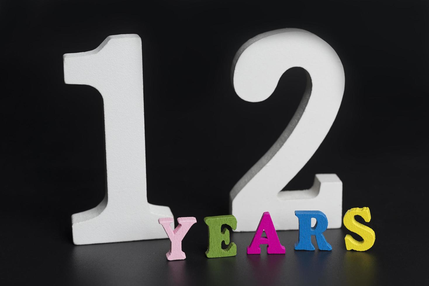 Letters and numbers for twelve years on a black background. photo