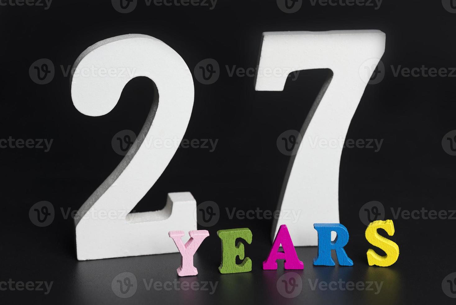 Letters and numbers twenty-seven years on a black background. photo