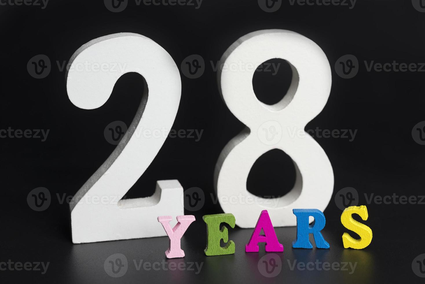 Letters and numbers twenty-eight years on a black background. photo