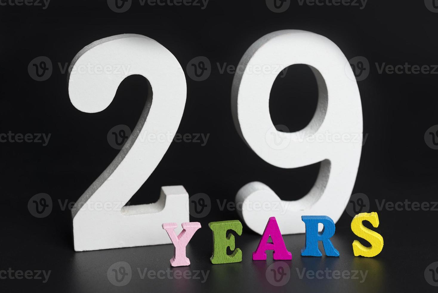 Letters and numbers twenty-nine years on a black background. photo