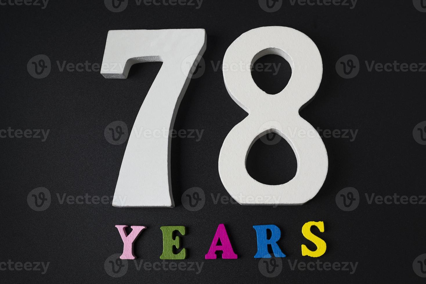 letras y números de setenta y ocho años sobre un fondo negro. foto