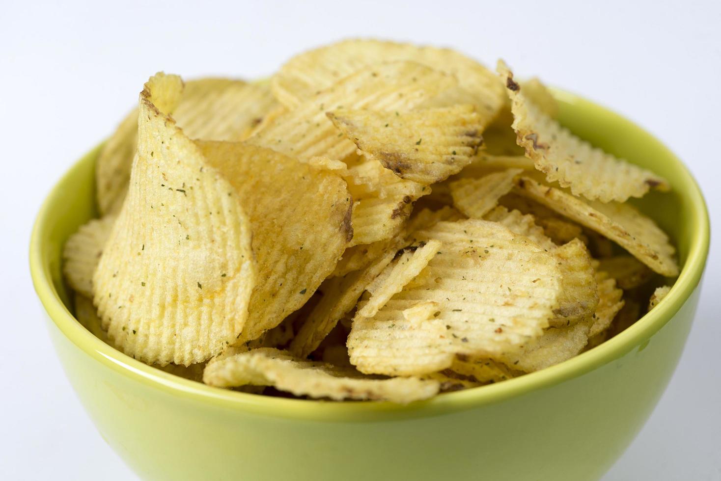 patatas fritas, chips estriados sobre un fondo blanco. foto