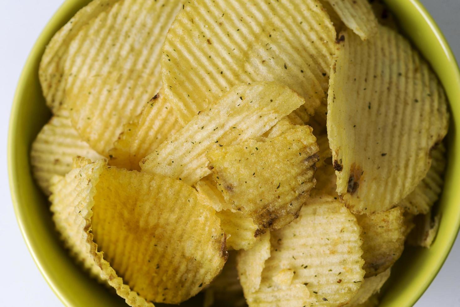 patatas fritas, chips estriados sobre un fondo blanco. foto