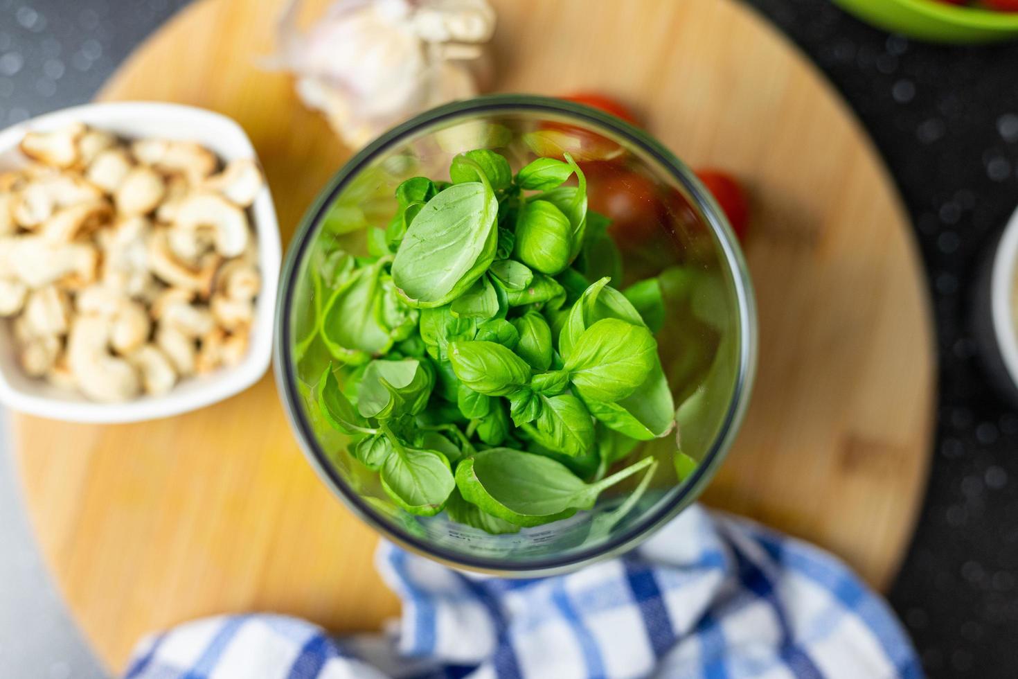 Basil leaves thrown into a blender. Prepare basil pesto. photo