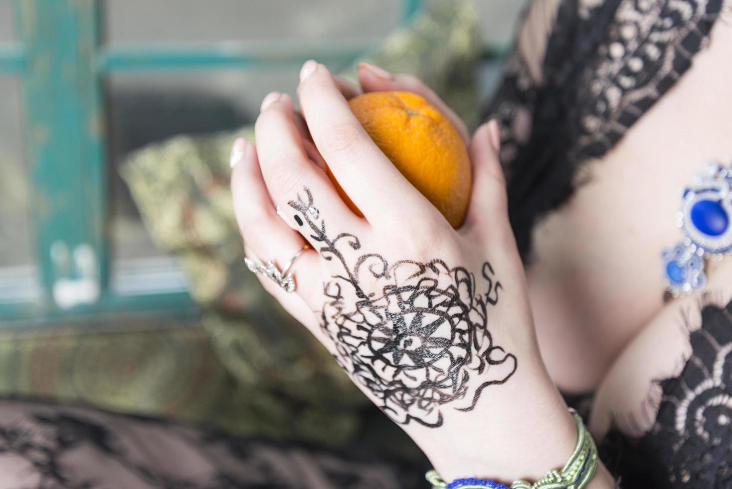 Young girl hand holds an orange. photo