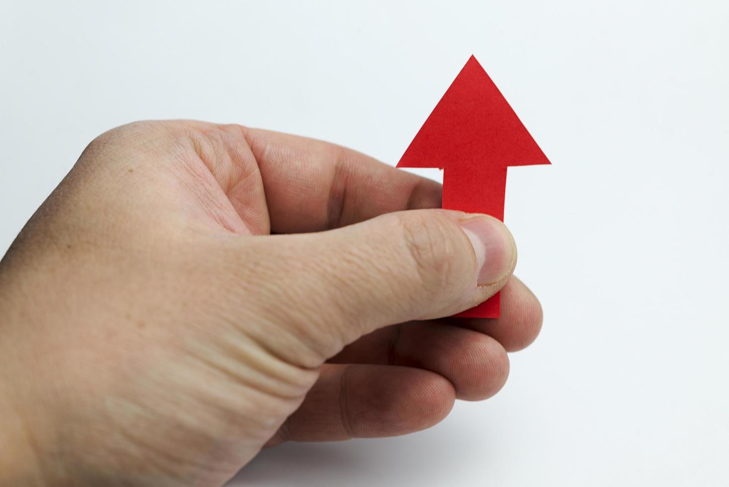 Hands holding up a red arrow. photo