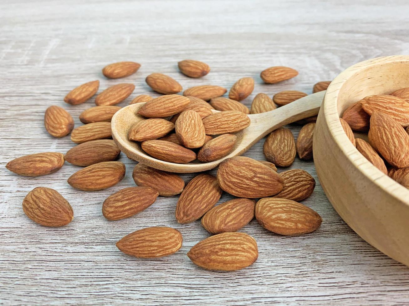 almond on wooden table with spoon, Almond in wooden bowl. photo