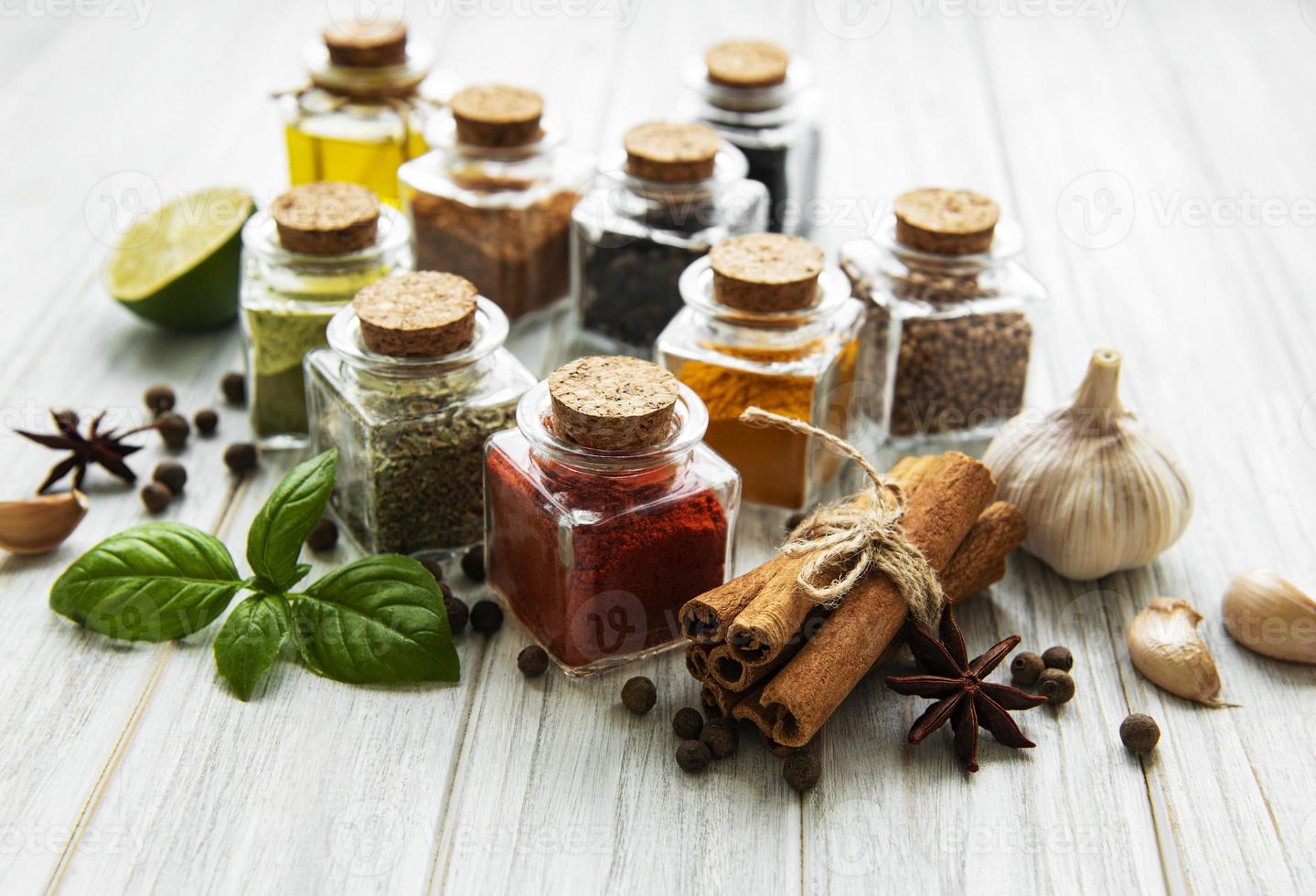 Jars with dried herbs, spices on the table photo