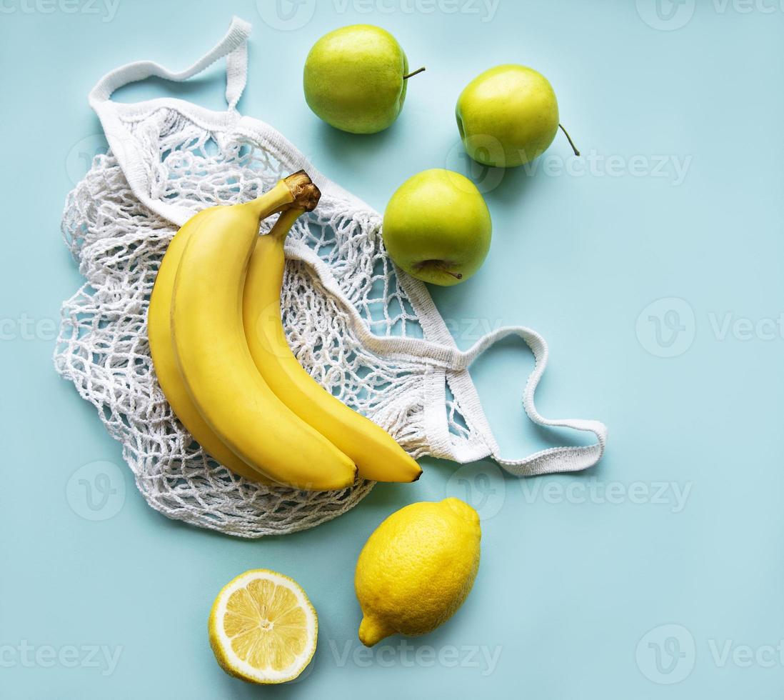 Juicy ripe citrus fruits and bananas in an eco-friendly shopping bag photo