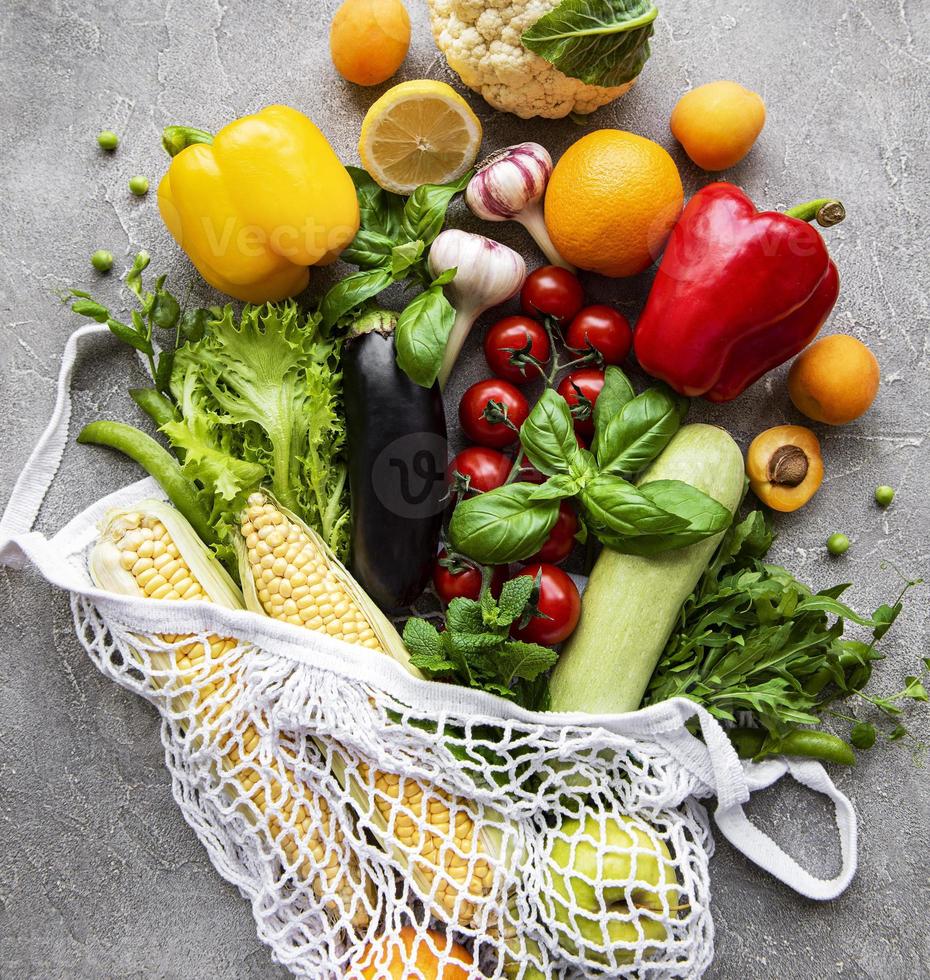 verduras y frutas frescas en bolsa de hilo ecológico sobre un fondo de hormigón. estilo de vida saludable. vista superior. cero desperdicio. foto