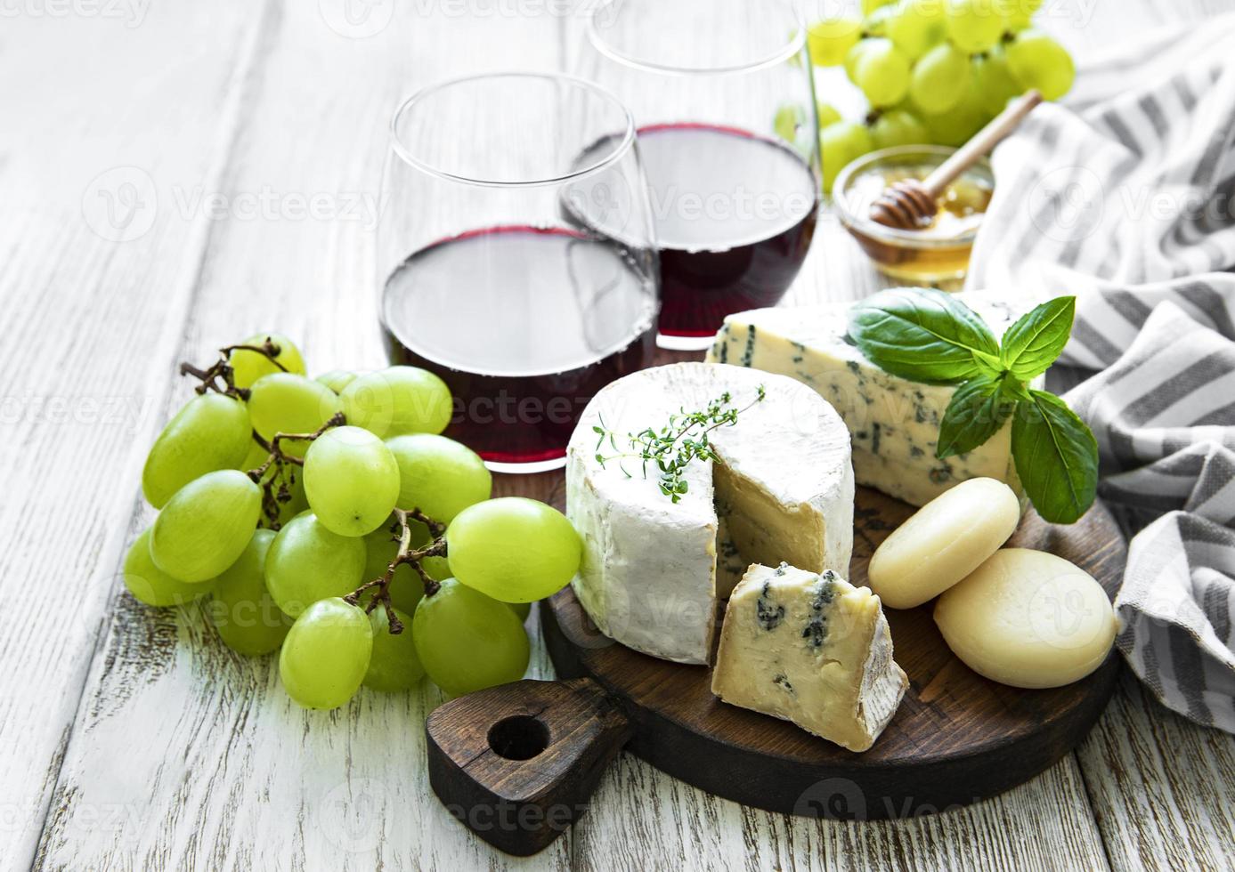 Various types of cheese, grapes and wine photo