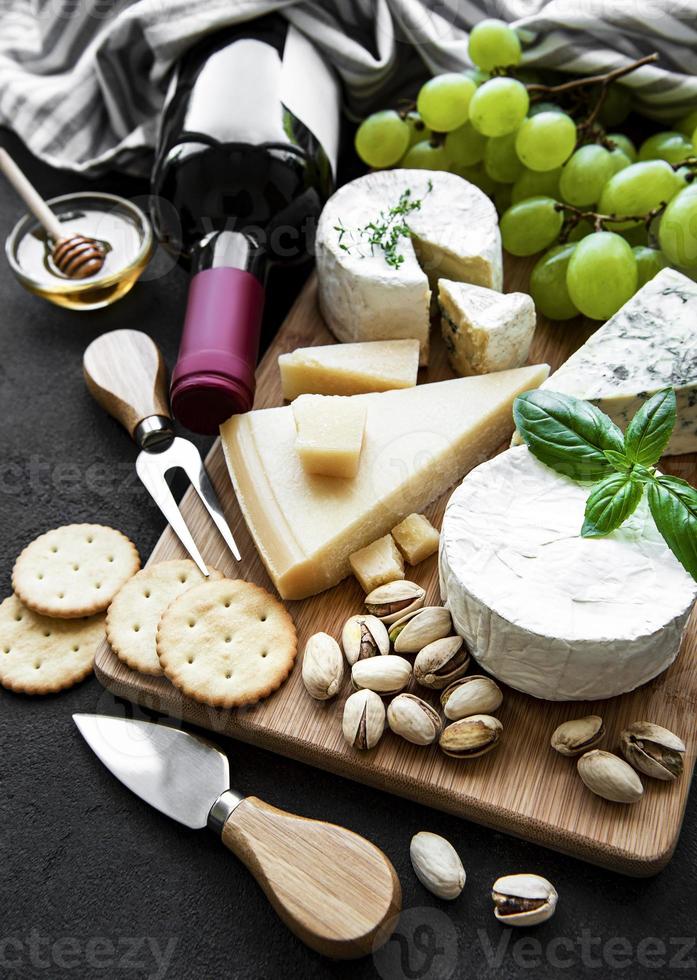 Various types of cheese, grapes and wine photo