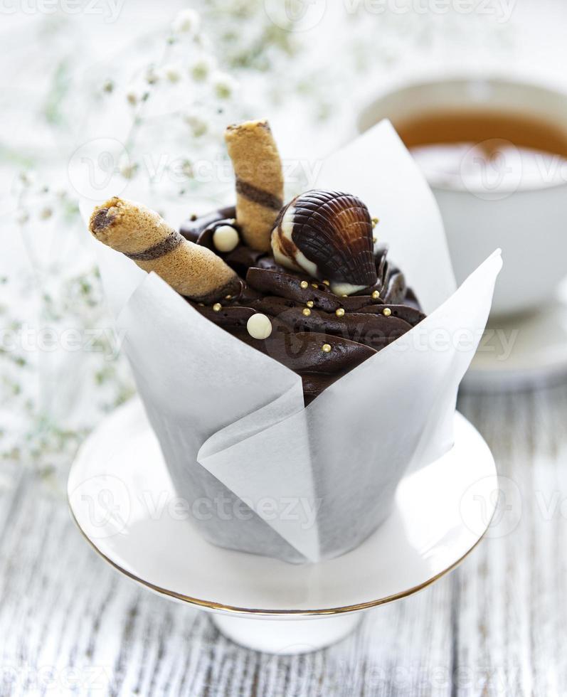 Chocolate cupcakes on white wooden background photo