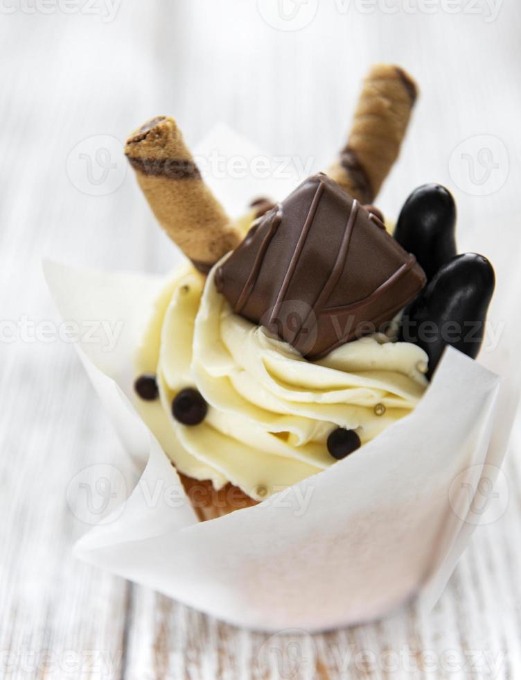 Chocolate cupcake on white wooden background photo